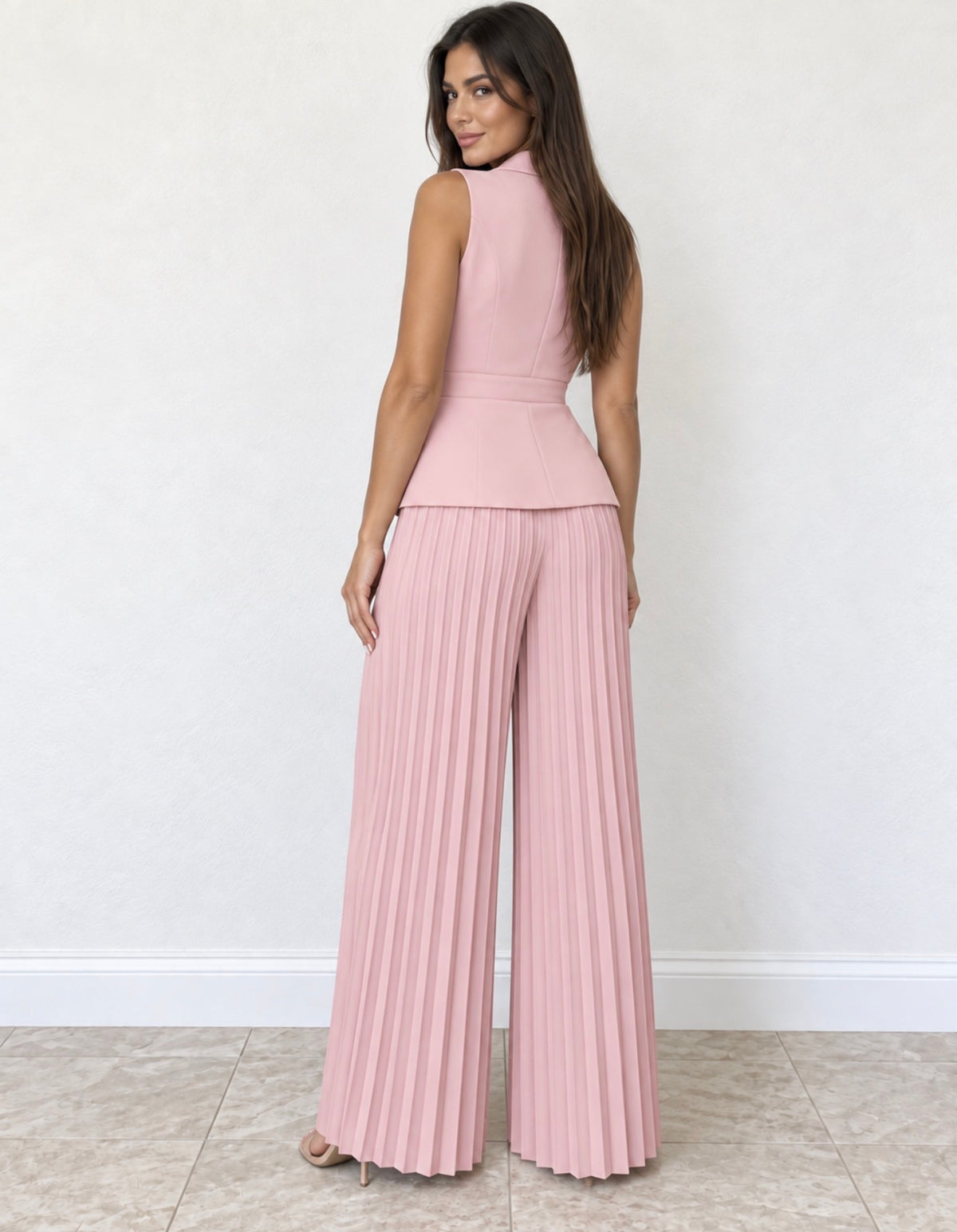 Mono rosa claro con chaleco cruzado y pantalón plisado